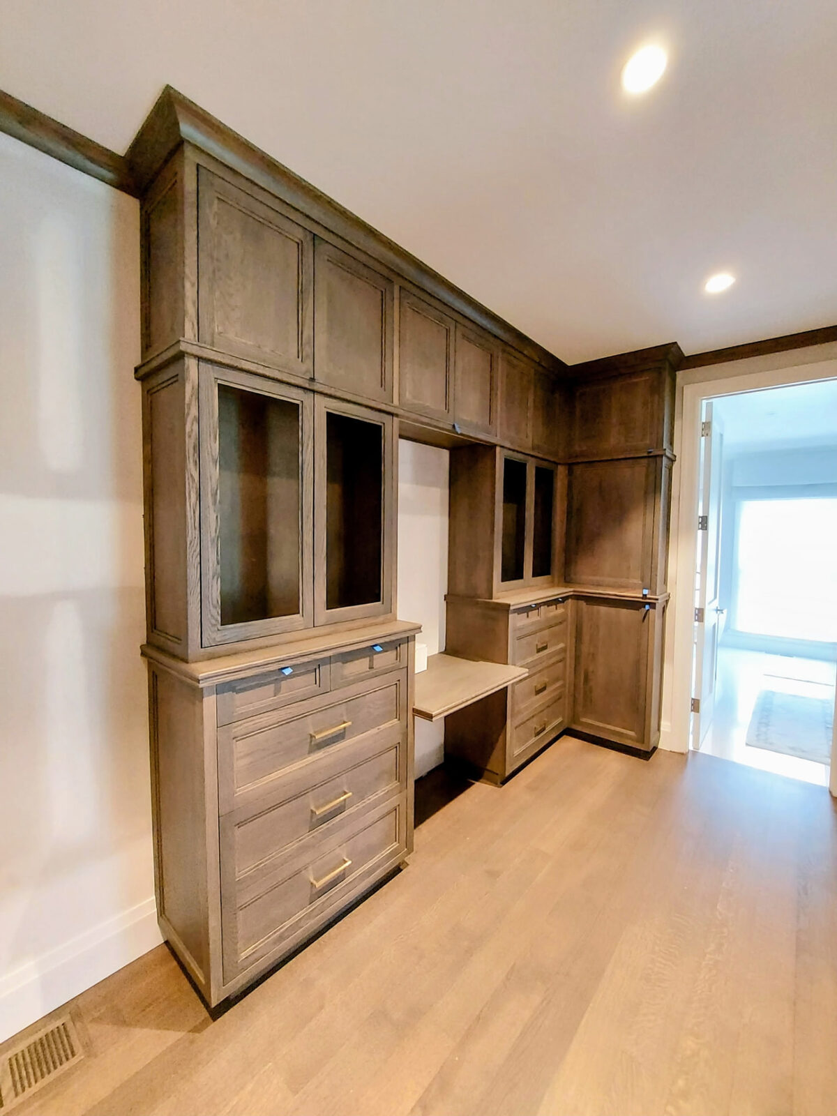 Custom home office cabinetry installation in Ridgefield Connecticut with drawers and doors hung on the stained built-in cabinets