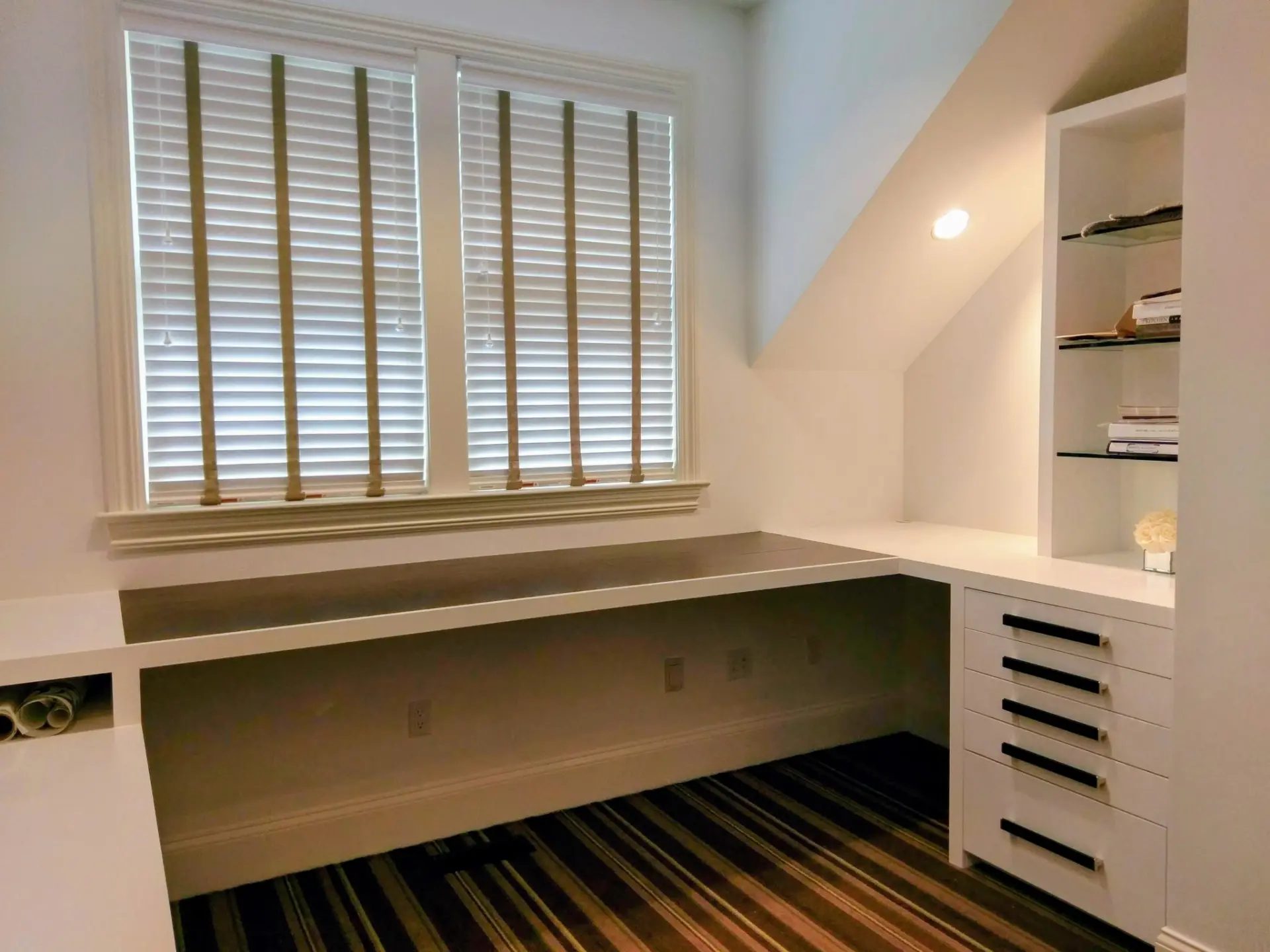 Custom white home office built-in with black Edelman Leather desktop, drawer storage and glass display shelving in a Ridgefield, CT home
