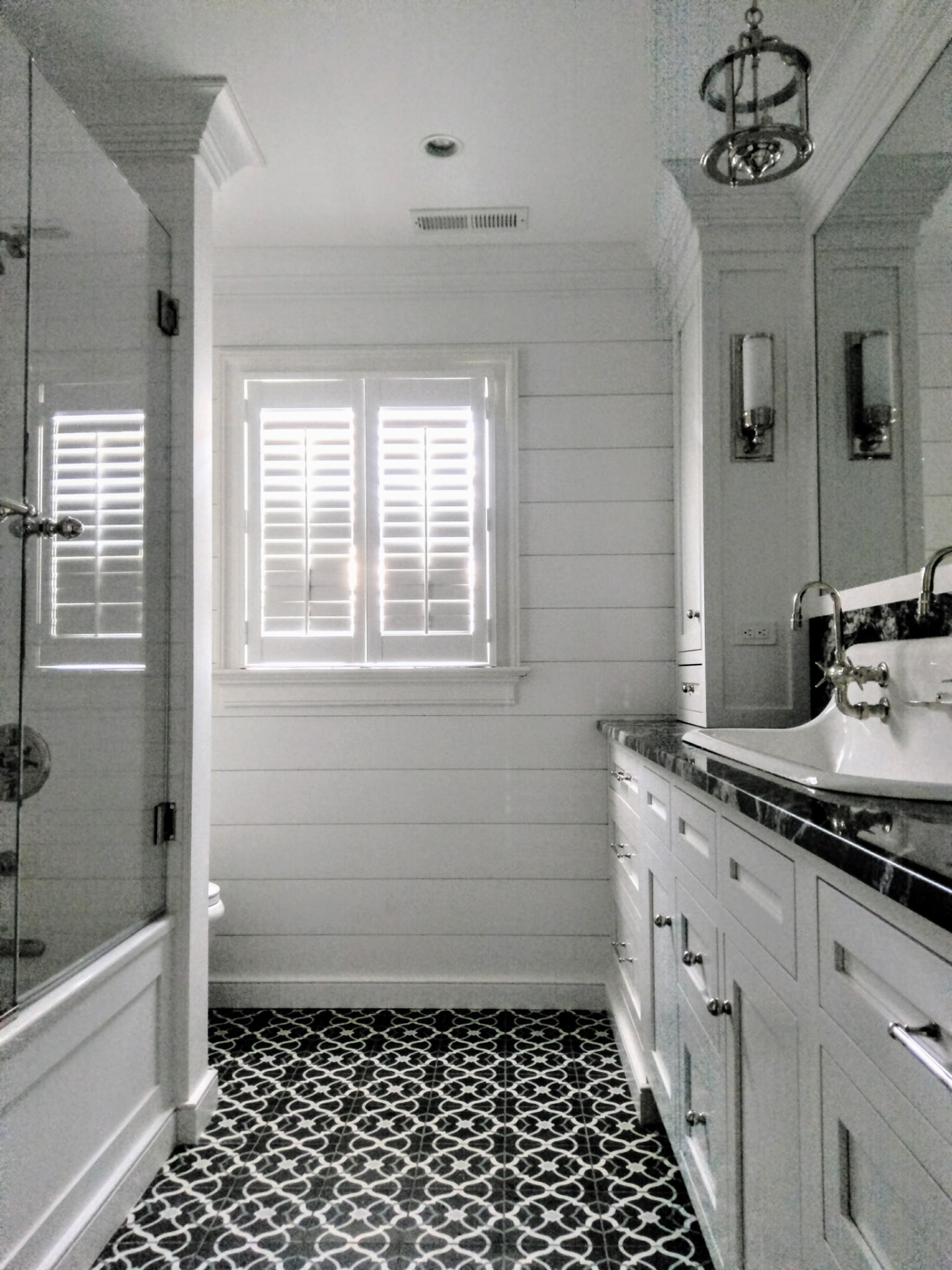 Full bathroom view with built-in cabinetry, shiplap walls and custom trim