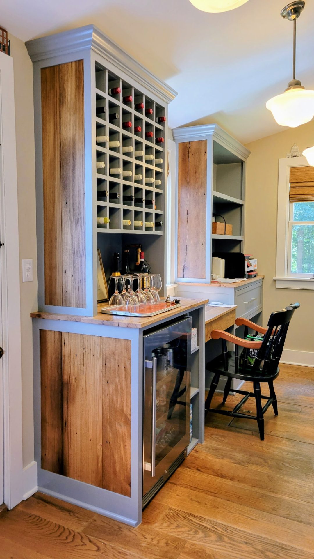 Custom wine storage with wood panels, bottle cubbies, and a beverage refrigerator in Ridgefield, CT.