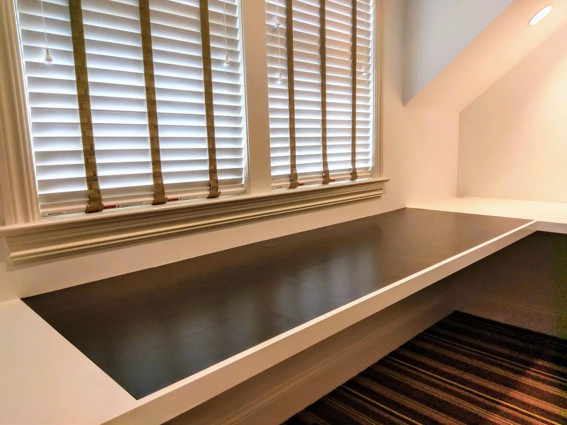 Black Edelman Leather desktop detail with white cabinetry and shuttered windows in the Ridgefield, CT home office