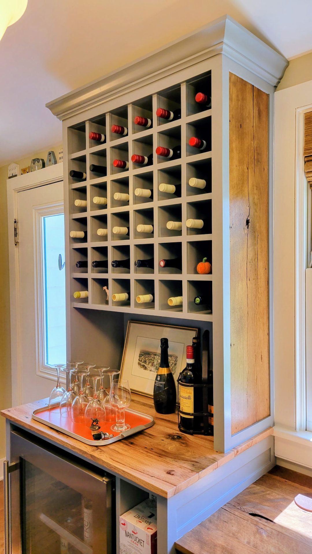 Built-in wine rack with bottle cubbies, wood countertop, and beverage refrigerator in Ridgefield, CT.